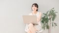 PCを前に考える女性